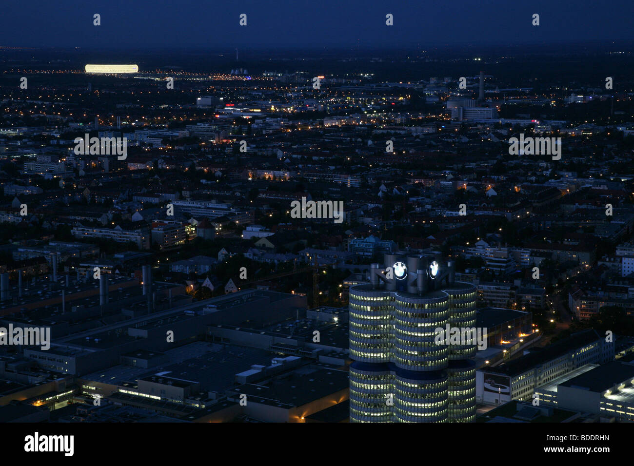The BMW headquarters building and in the distance the FC Bayern football stadium at night. Munich, Germany. Stock Photo