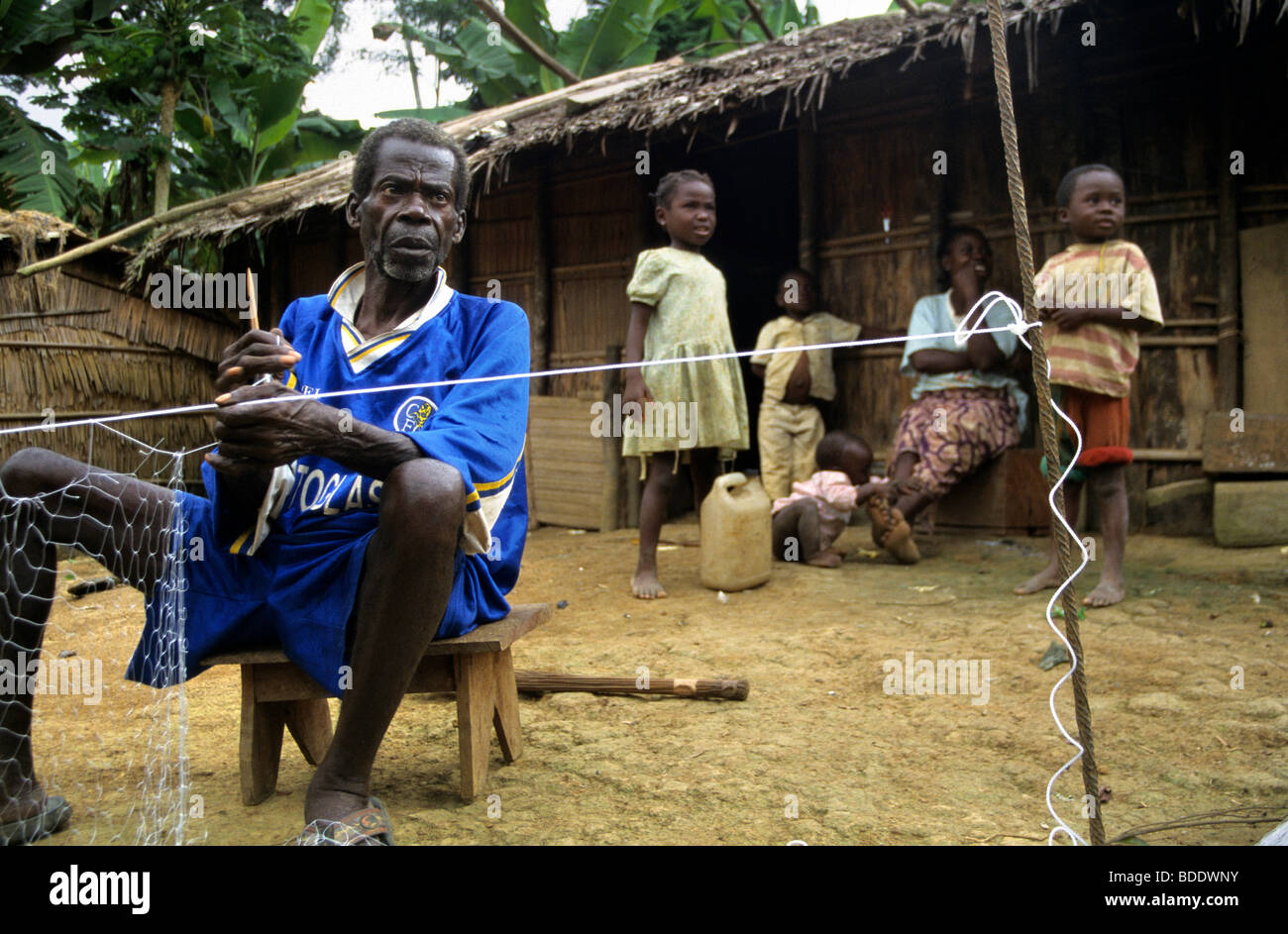 An elderly Baka Pygmy man making a fishing net in his remote village in the rainforest bordering Gabon and Congo, Central Africa Stock Photo