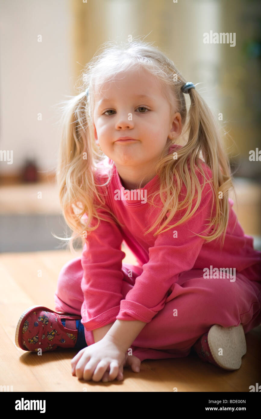 Portrait of a little girl sitting on the floor Stock Photo Alamy