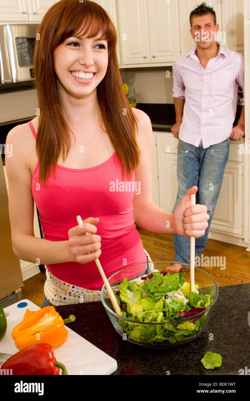 Couple in kitchen making a salad. Stock Photo