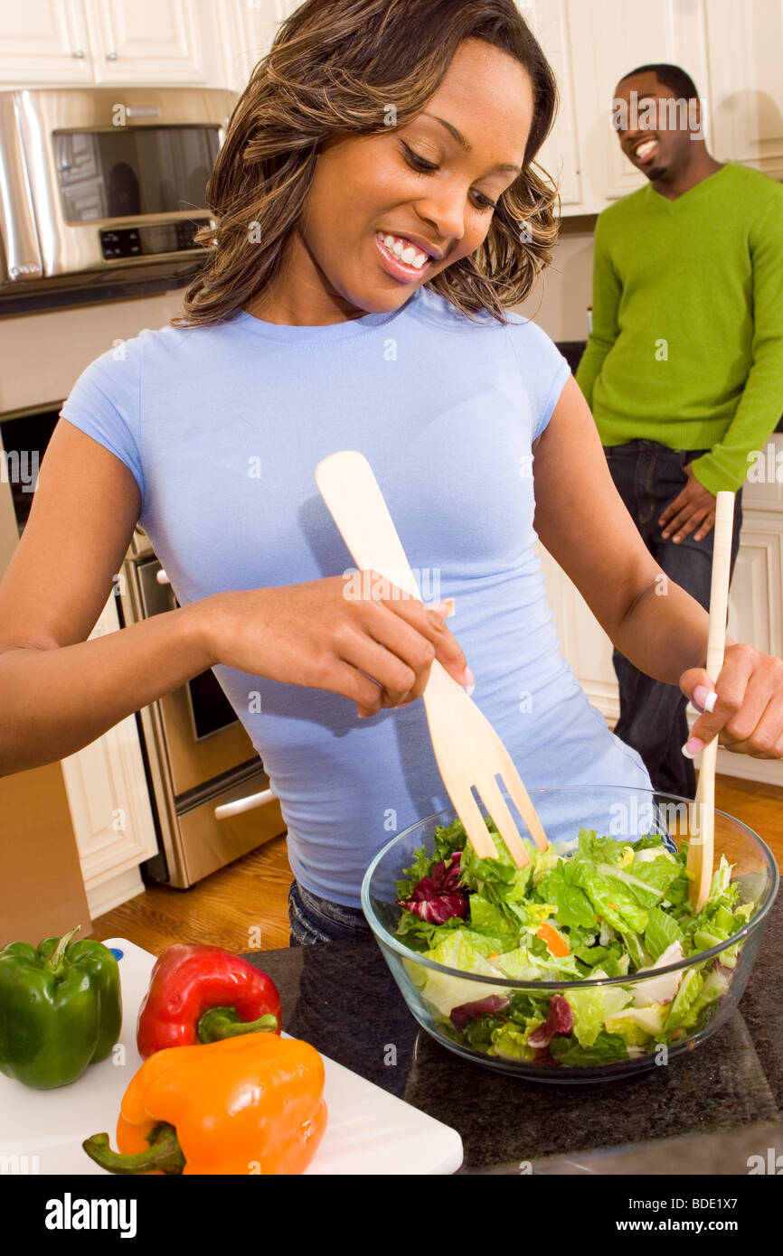 Couple in kitchen making a salad. Stock Photo
