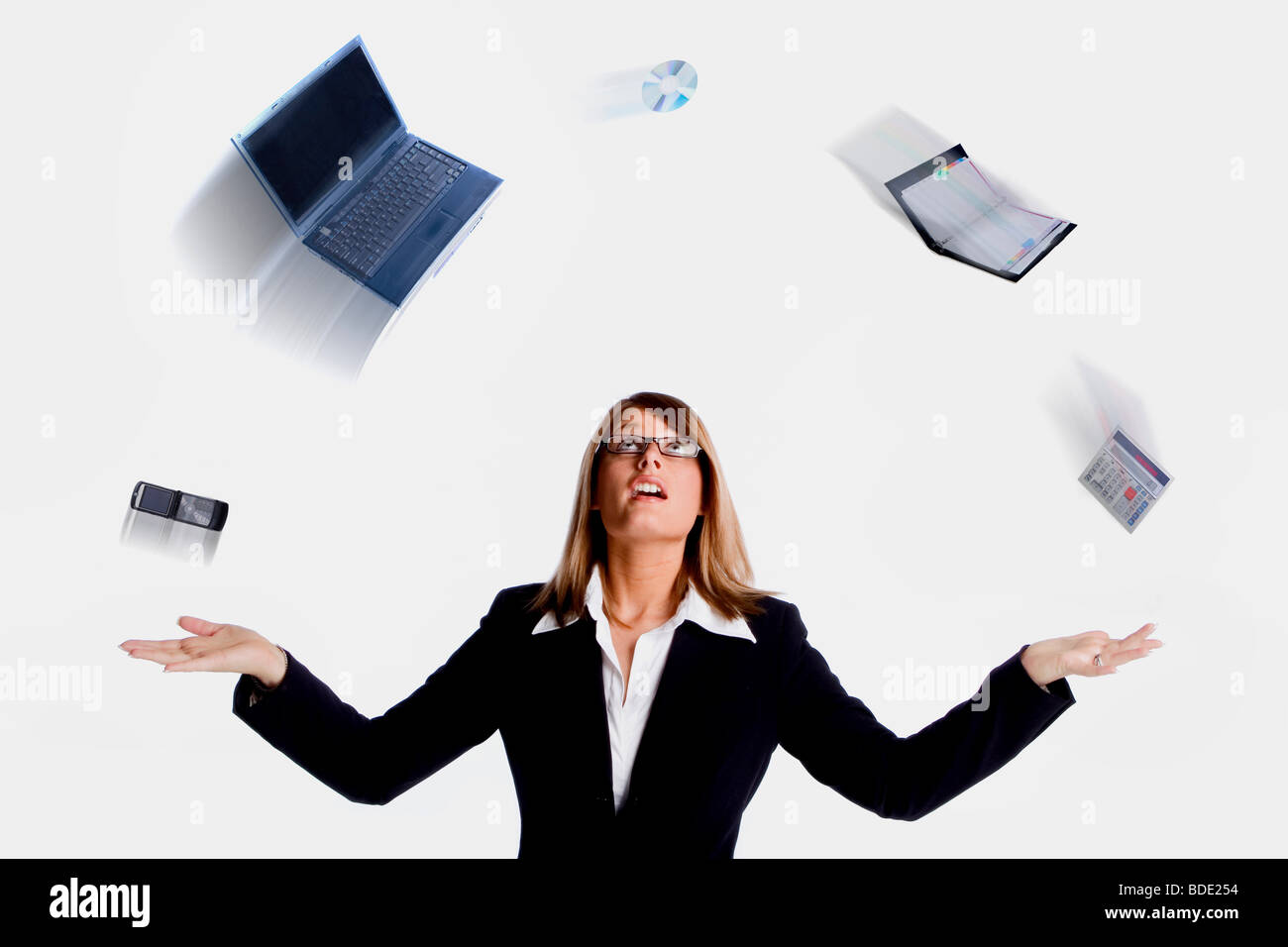 Young Professional Business Woman juggling various office items Stock