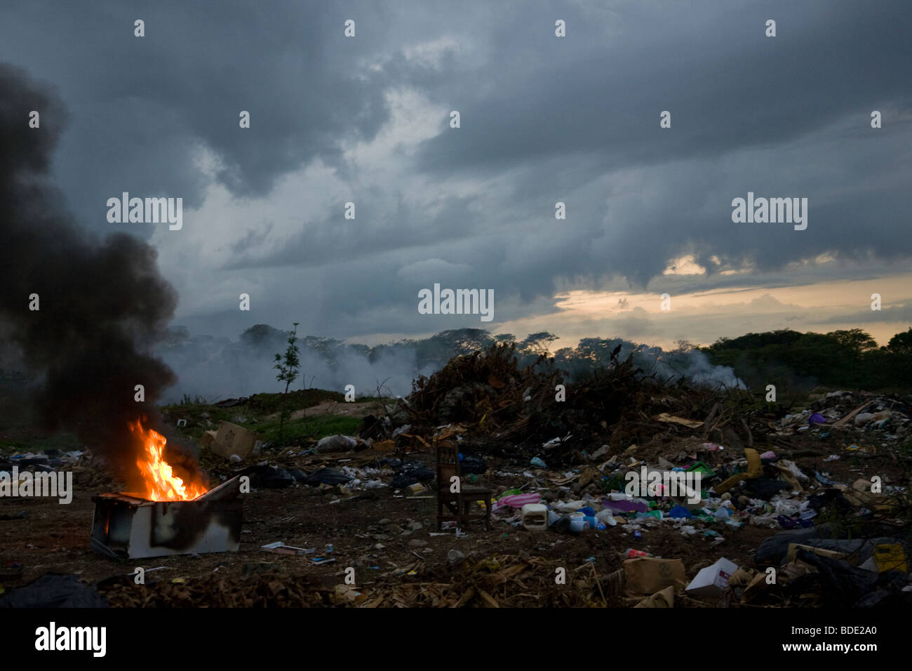 Trash burning in a garbage dump at twilight in Alajuela, Costa Rica. Stock Photo