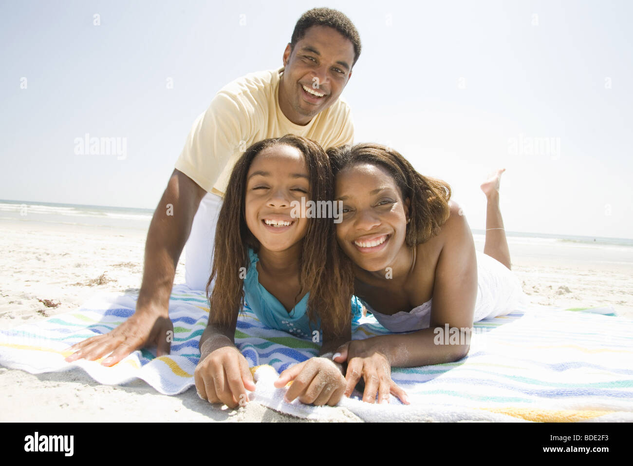 Father and Mother playing on the beach with family Stock Photo