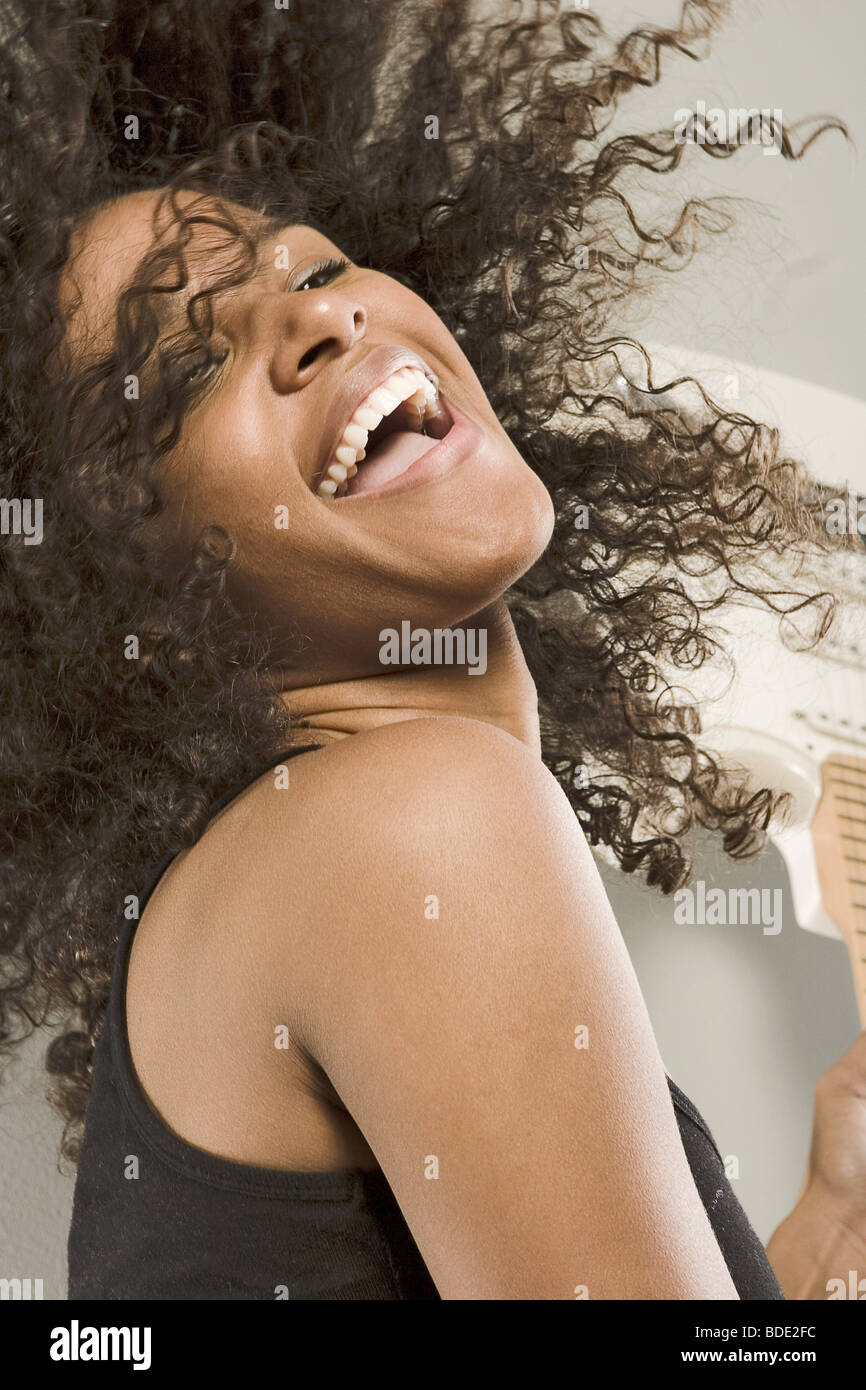 Beautiful young woman dancing and playing the guitar Stock Photo - Alamy