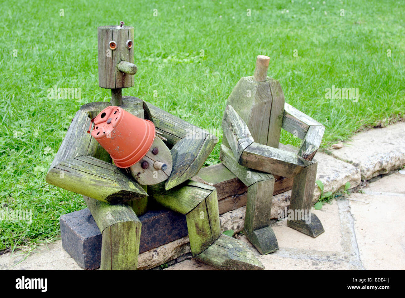 Wooden figures sitting near garden lawn England UK Stock Photo Alamy