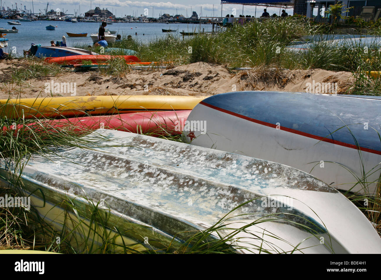 Upturned row boats and kayaks in sand and beach grass on Cape Cod Bay, Massachusetts. Stock Photo