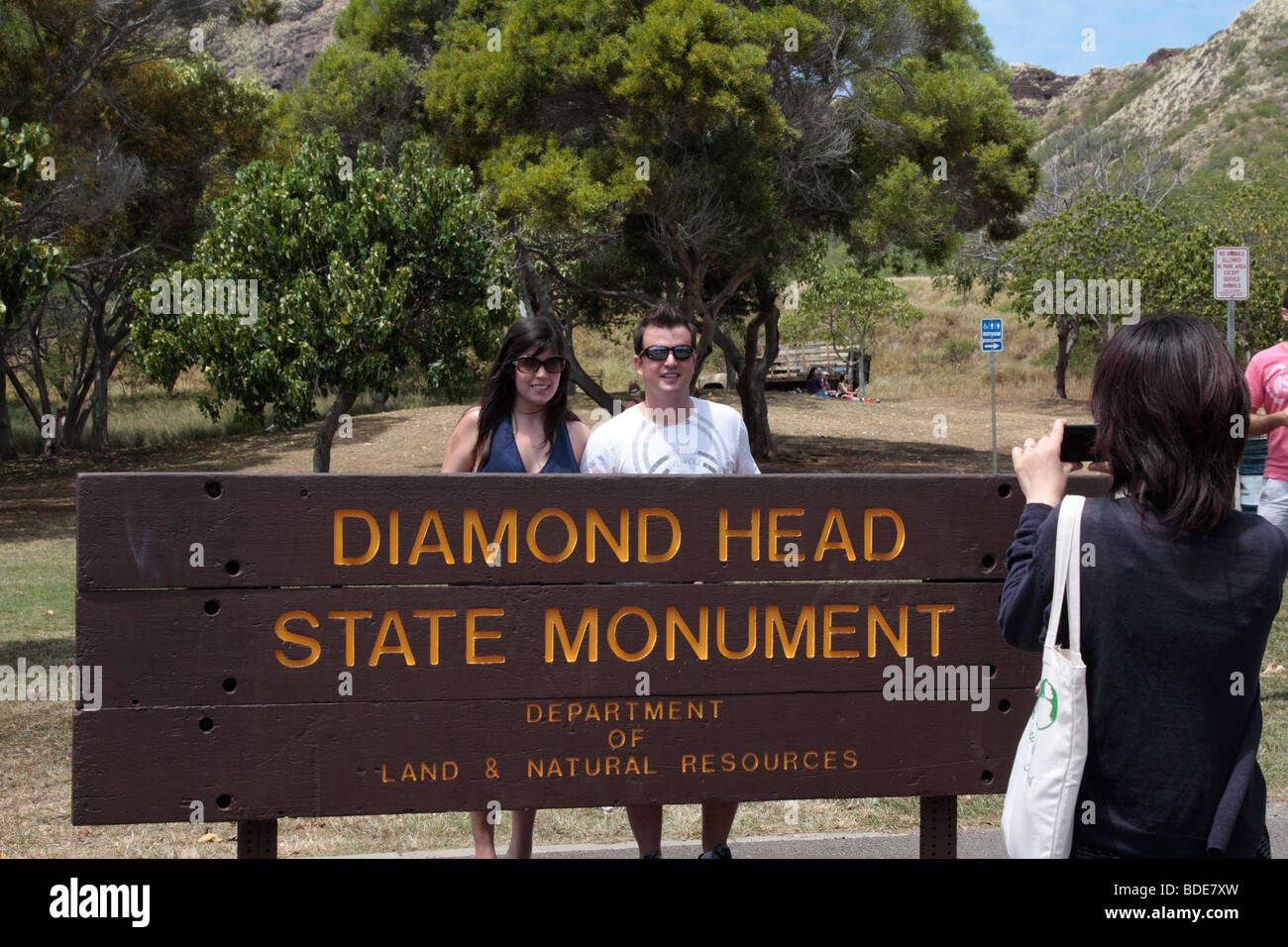 Visitors to Diamond Head Park being photographed by the sign at the