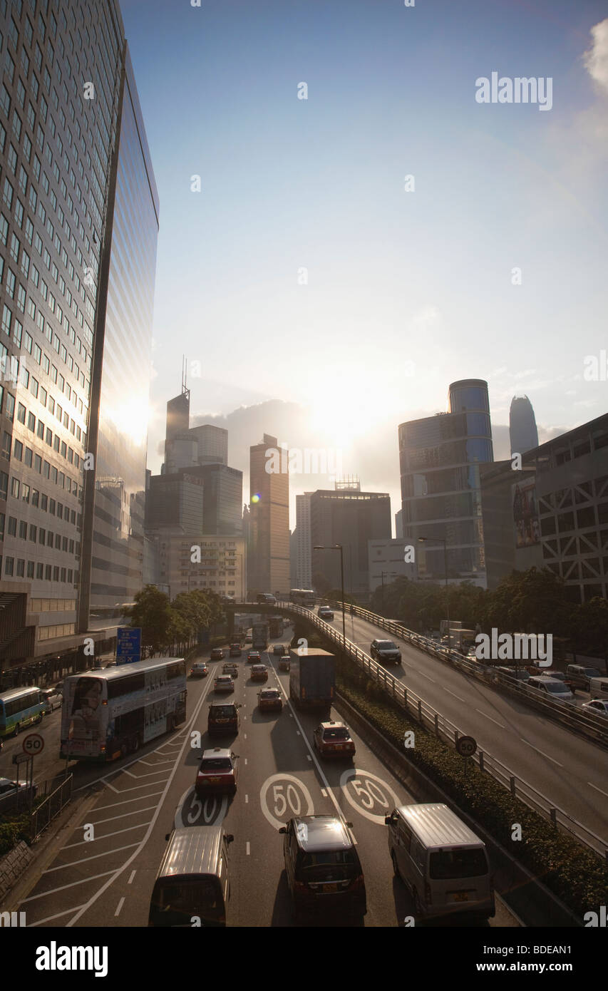 Evening light reflecting on traffic and road heading towards high rise buildings in Hong Kong, China. Stock Photo