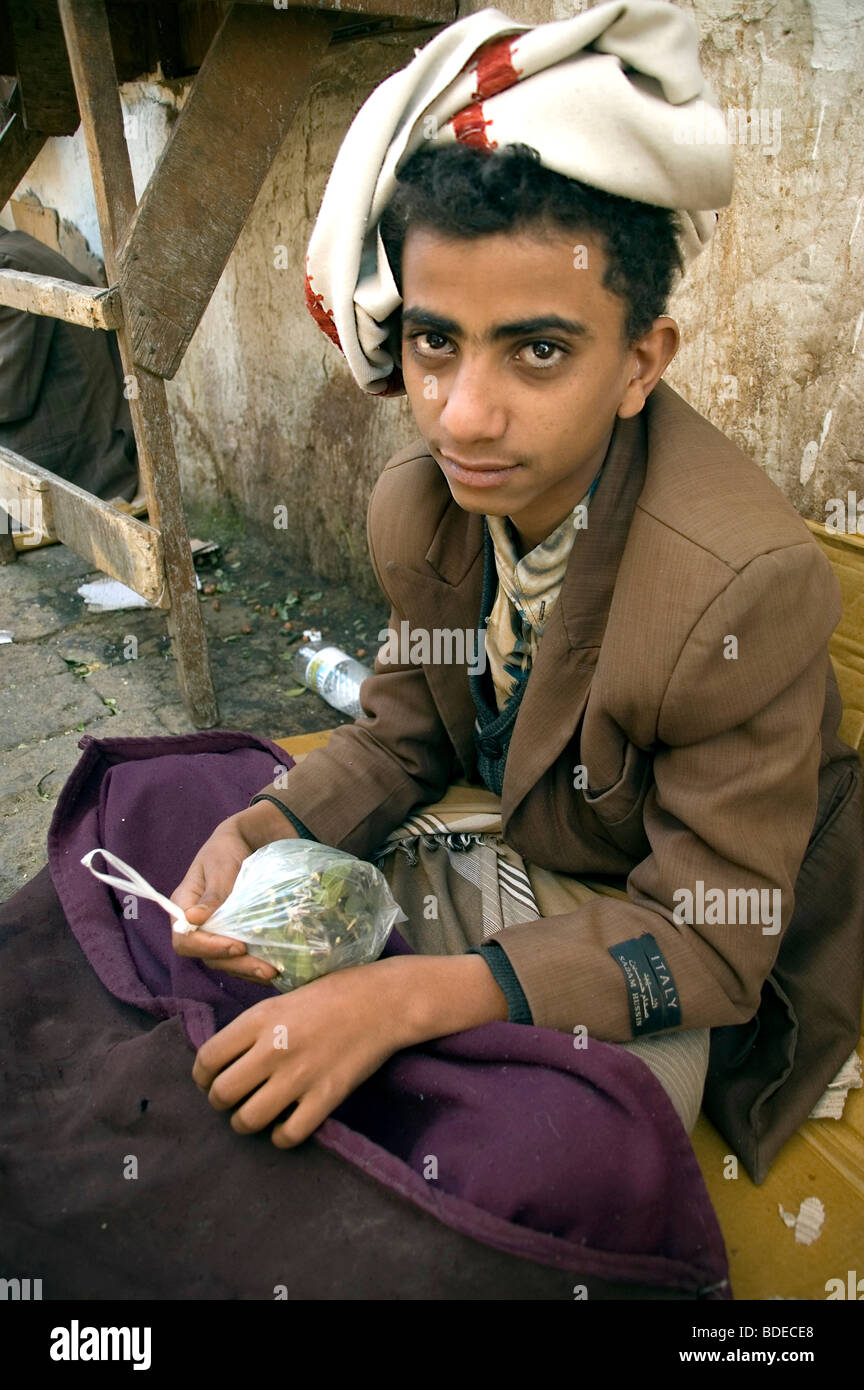 A young teenager selling bags of khat or qat - a chewable leafy stimulant and legal drug in the market in Sanaa, Yemen. Stock Photo