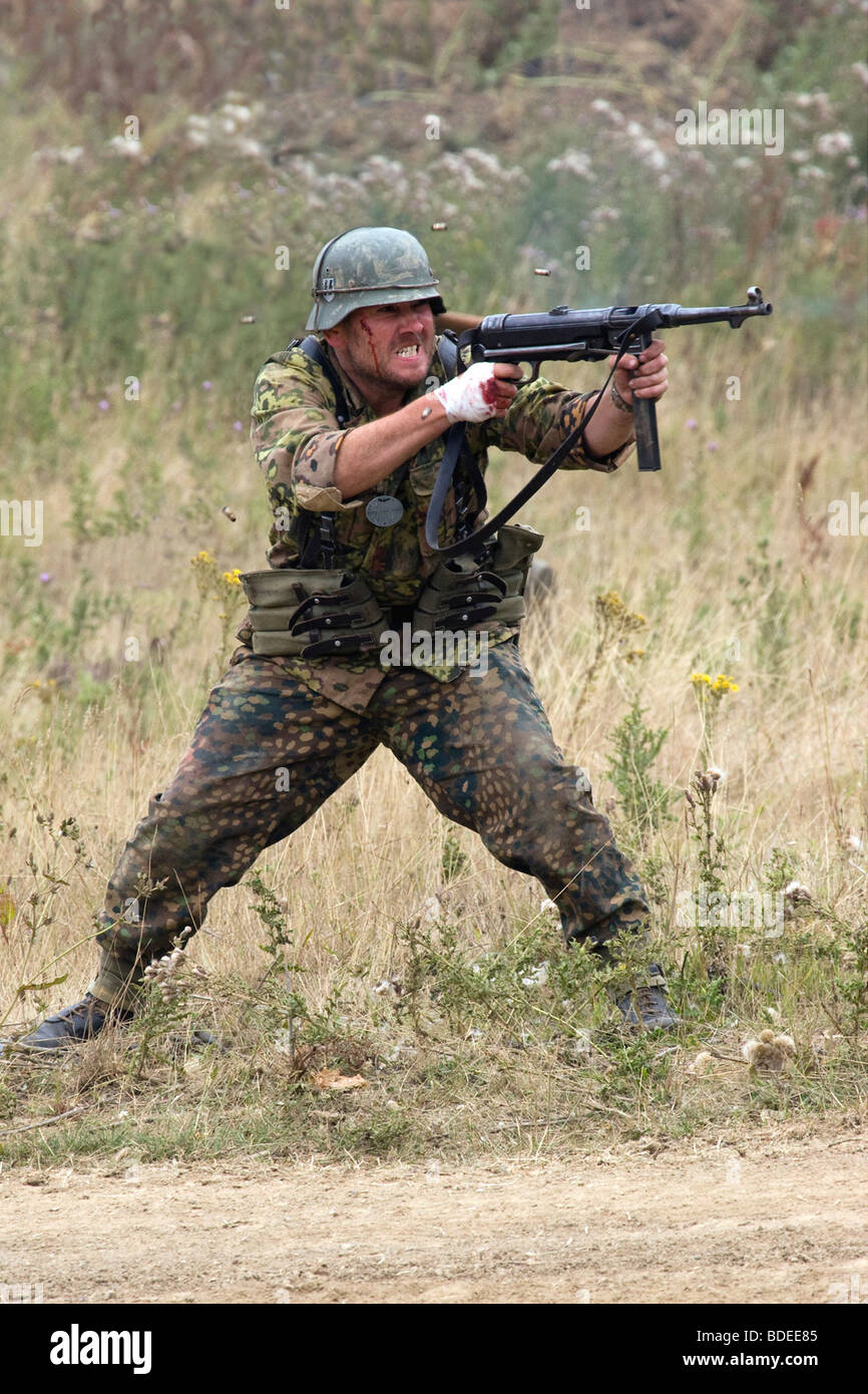 Portrait View Of A Re-enactor As A Panzer Grenadier Shooting His Machine Gun Stock Photo