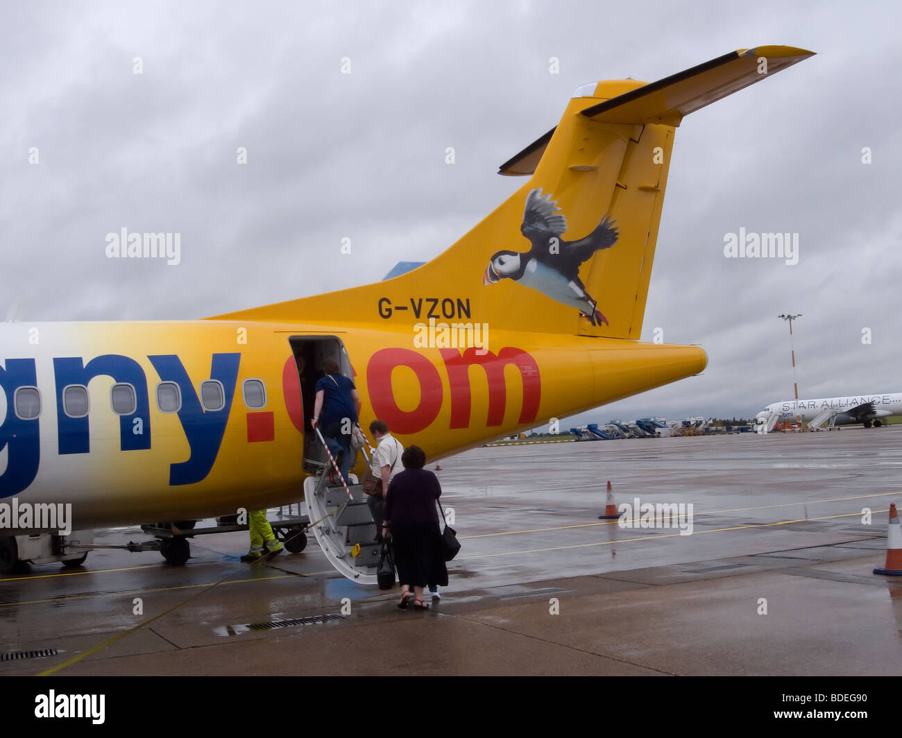 Passengers boarding an Aurigny Airline A72 aircraft on a rainy day at East Midlands Airport bound for Guernsey Stock Photo