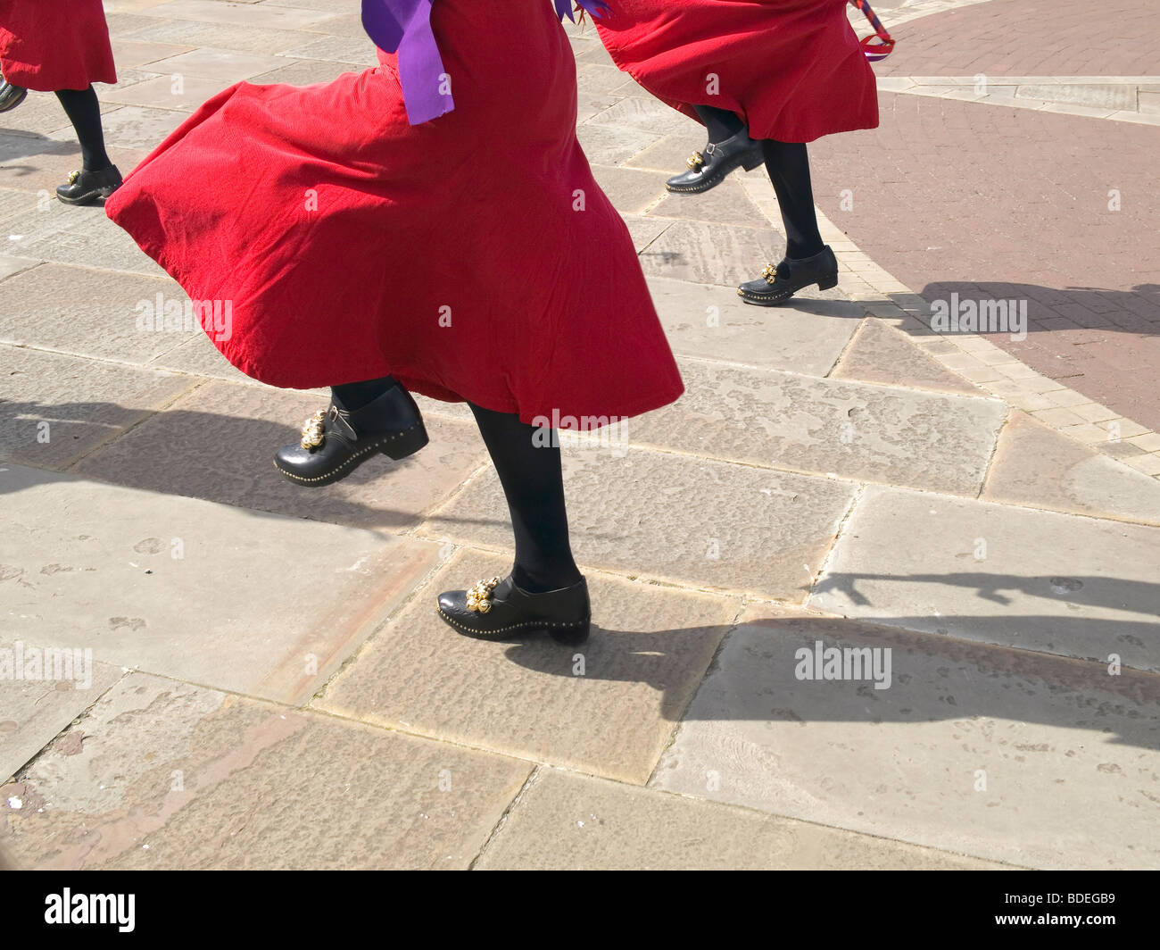 Close up of lively women Morris Dancers red skirts feet and clogs Stock Photo