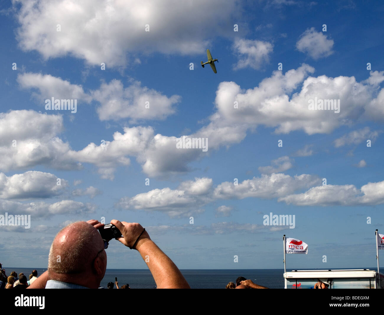 A man photographing a Hawker Hurricane aircraft during a fly past of the Battle of Britain Memorial Flight Whitby Regatta 2009 Stock Photo