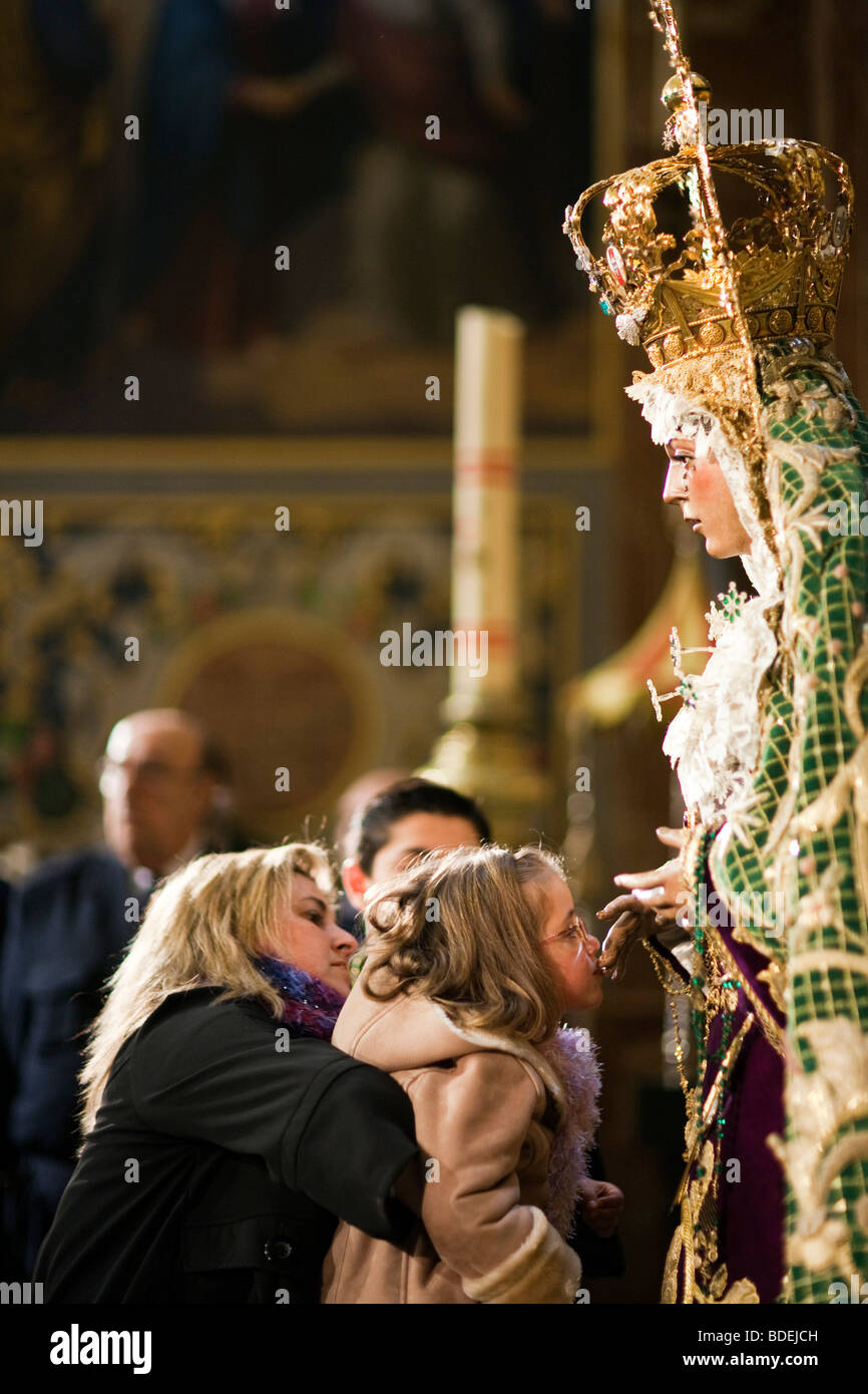 Little girl kissing Macarena Virgin's hand, Macarena Basilica, Seville, Andalusia, Spain Stock Photo