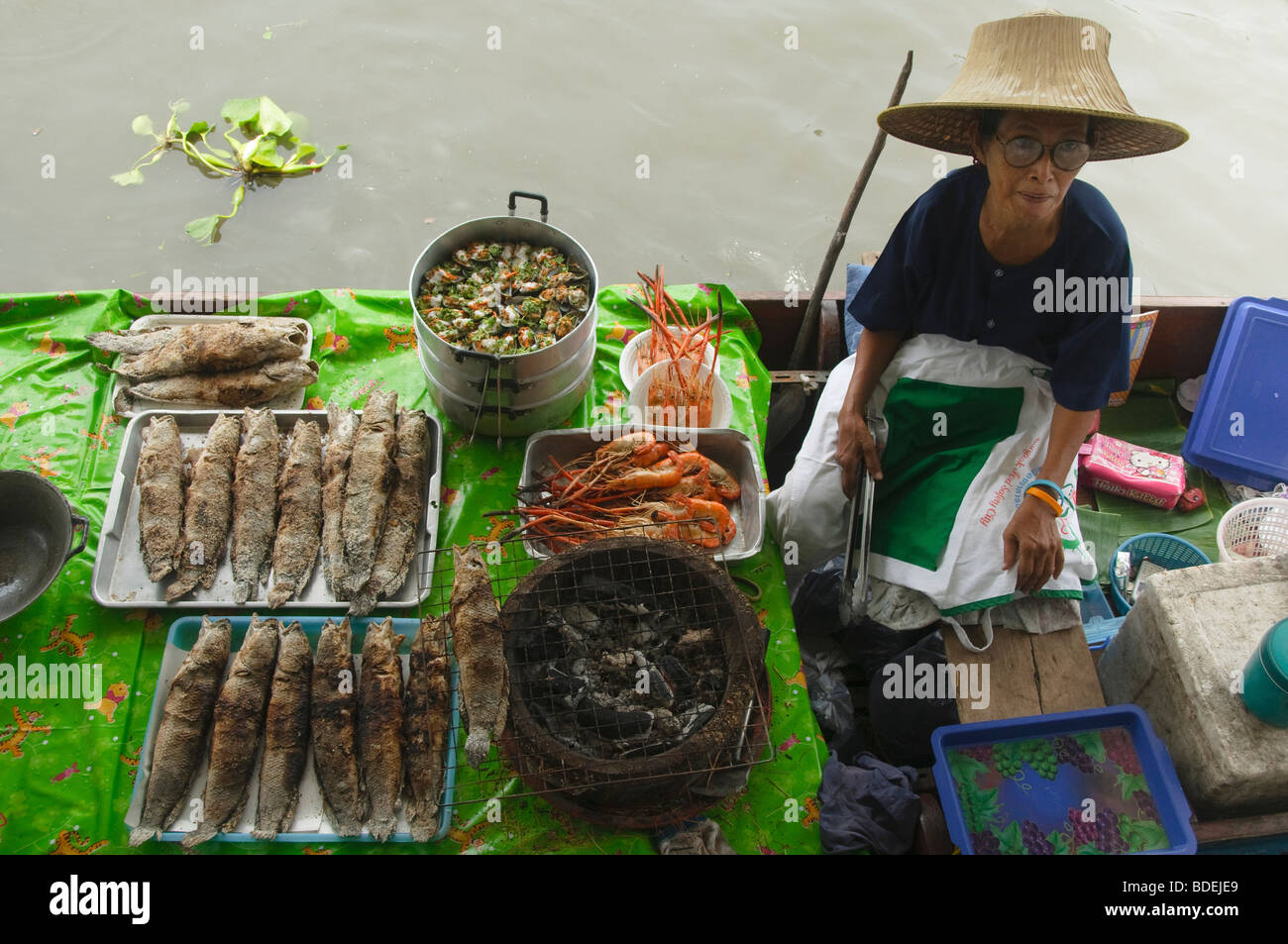 vendor and her seafood barbecue at a floating market in Bangkok Thailand Stock Photo