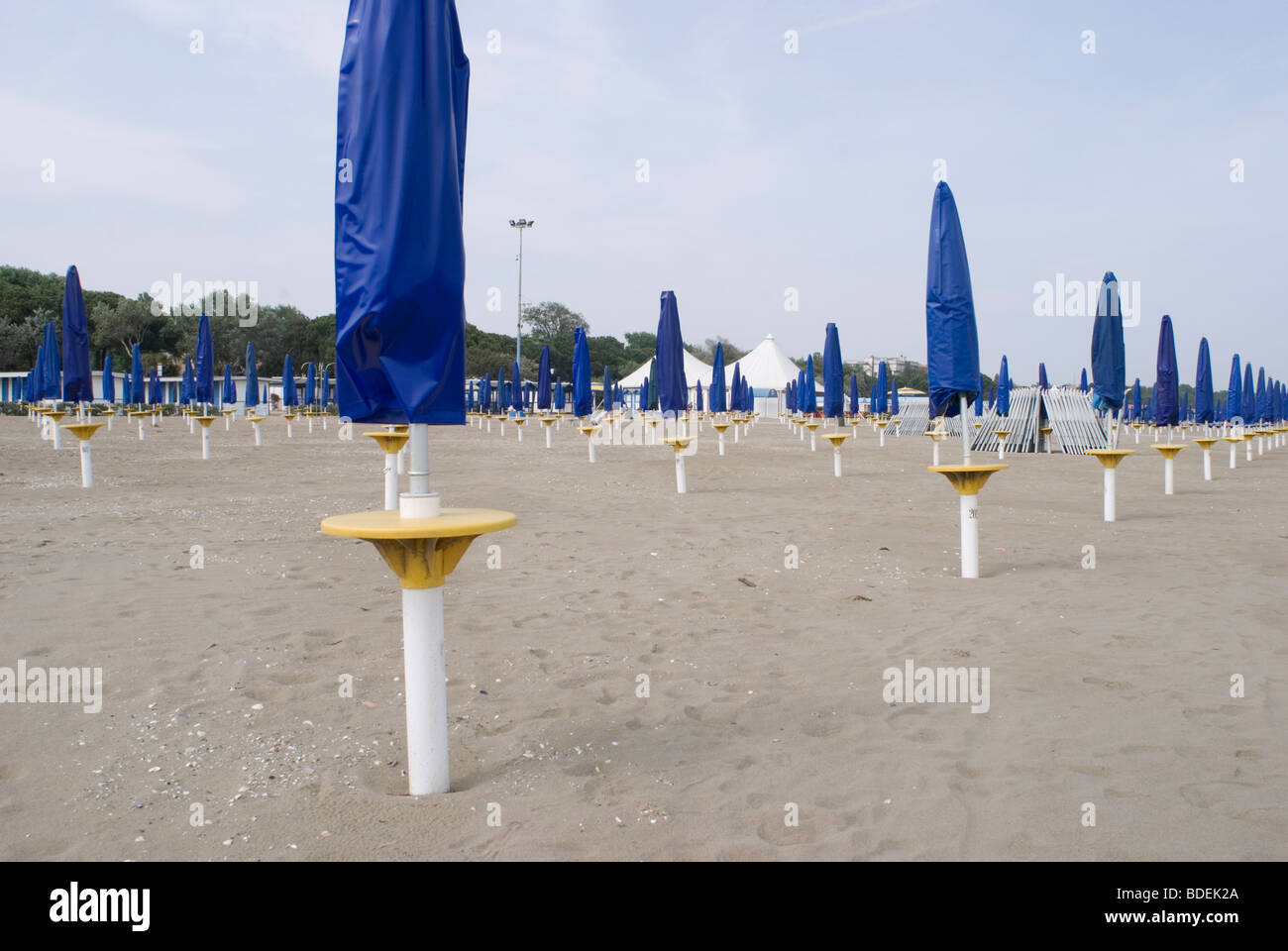 rows of folded sunshades in Venice Lido - Italy Stock Photo