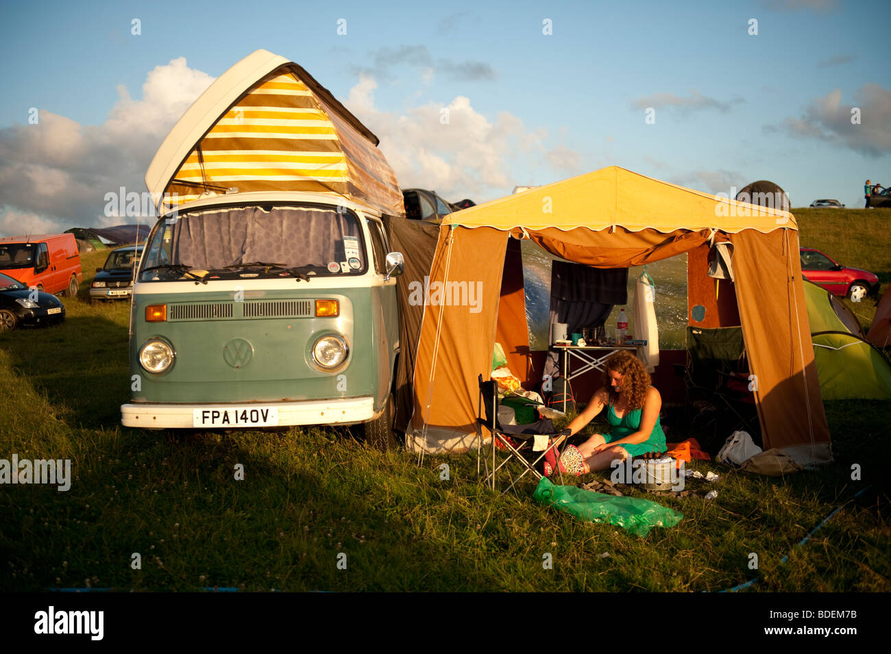 A young woman camping with her tent an VW campervan at The Square Festival, Borth, July 2009. Wales UK Stock Photo