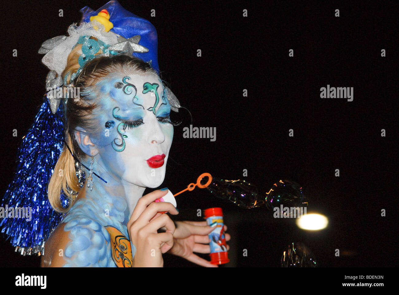 young female model with make up mask blows bubbles Stock Photo