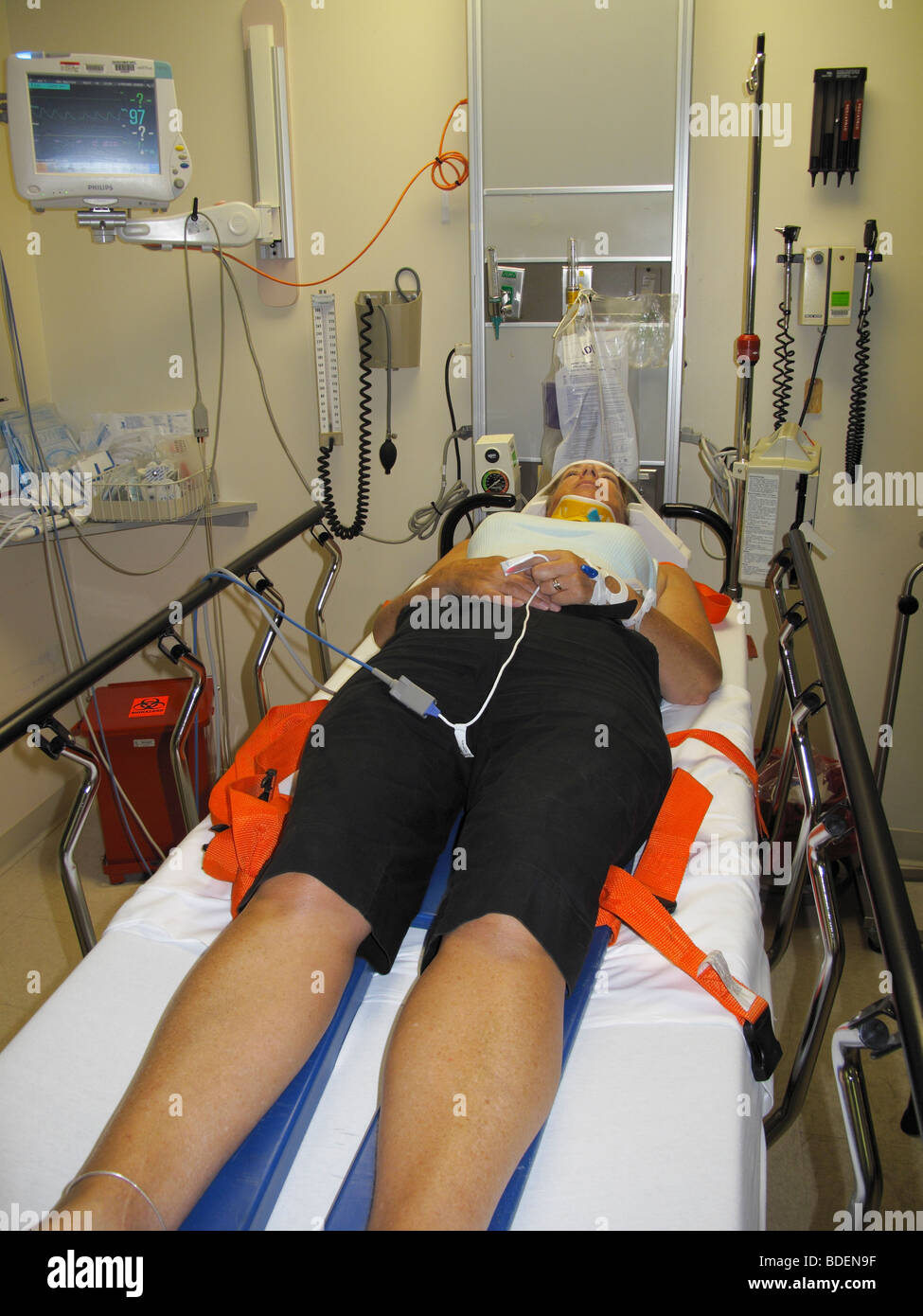 A woman who was in a car accident in a hospital emergency room restrained on an examination table Stock Photo