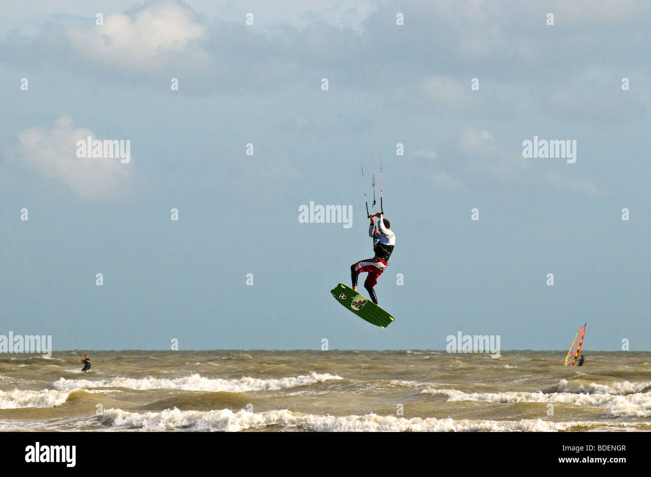 A parasurfer performing acrobatic jumps in the sea off Camber sands in