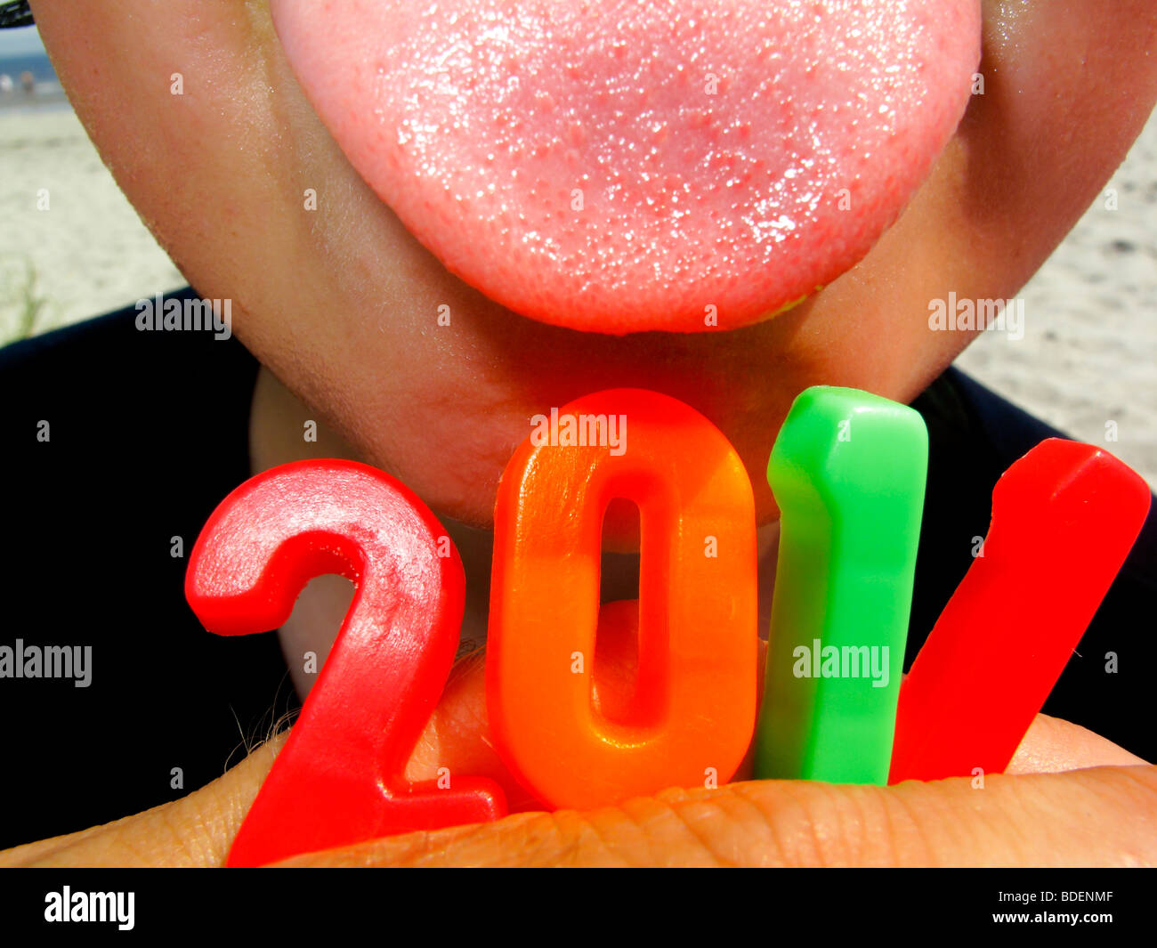 a child with his tongue out holding the year 2011 in numbers Stock Photo