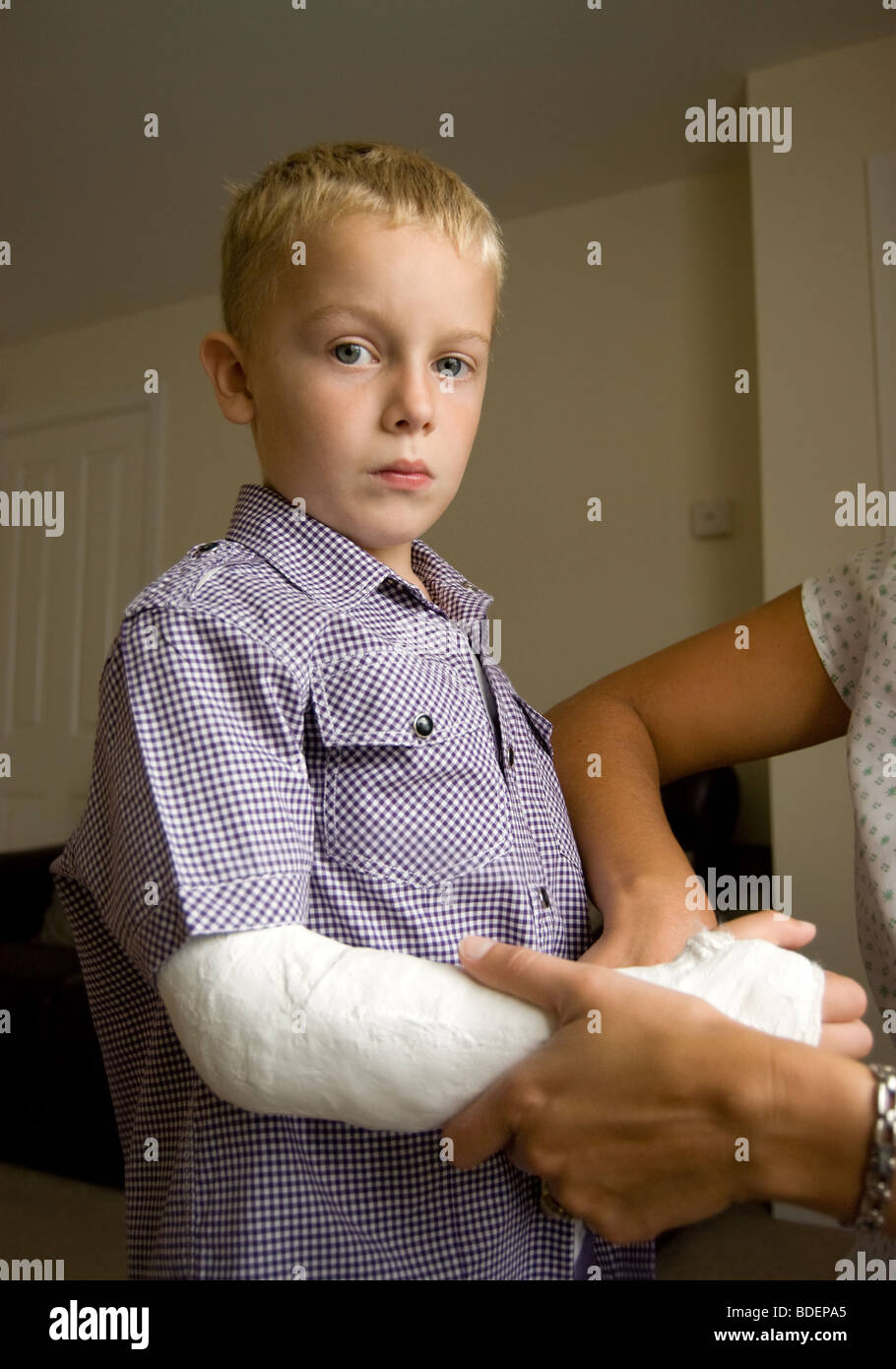Boy with a broken arm being helped by his mother Stock Photo Alamy