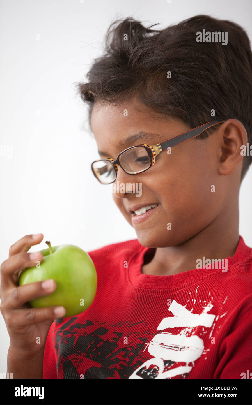 Little boy looking at a green apple Stock Photo