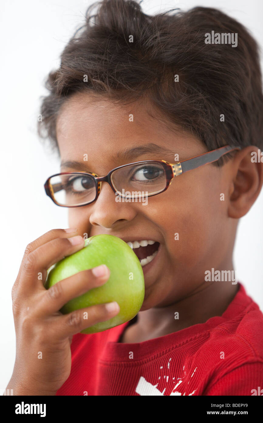 Little boy from Hindu origin eating an apple Stock Photo