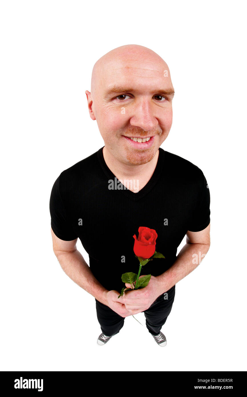 bald headed man holding a red rose in his hands Stock Photo