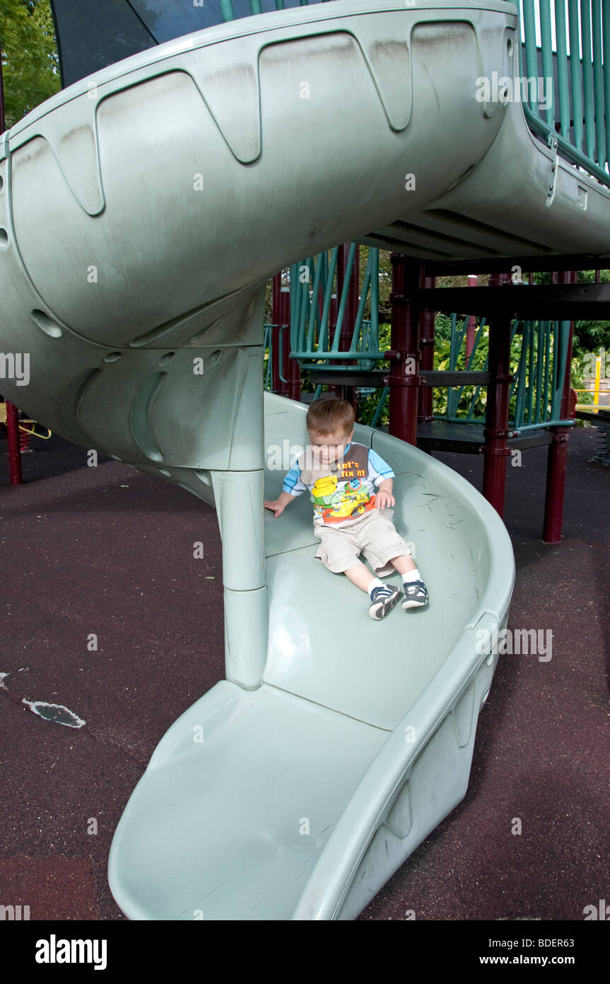Young boy playing on a slide at a park Stock Photo