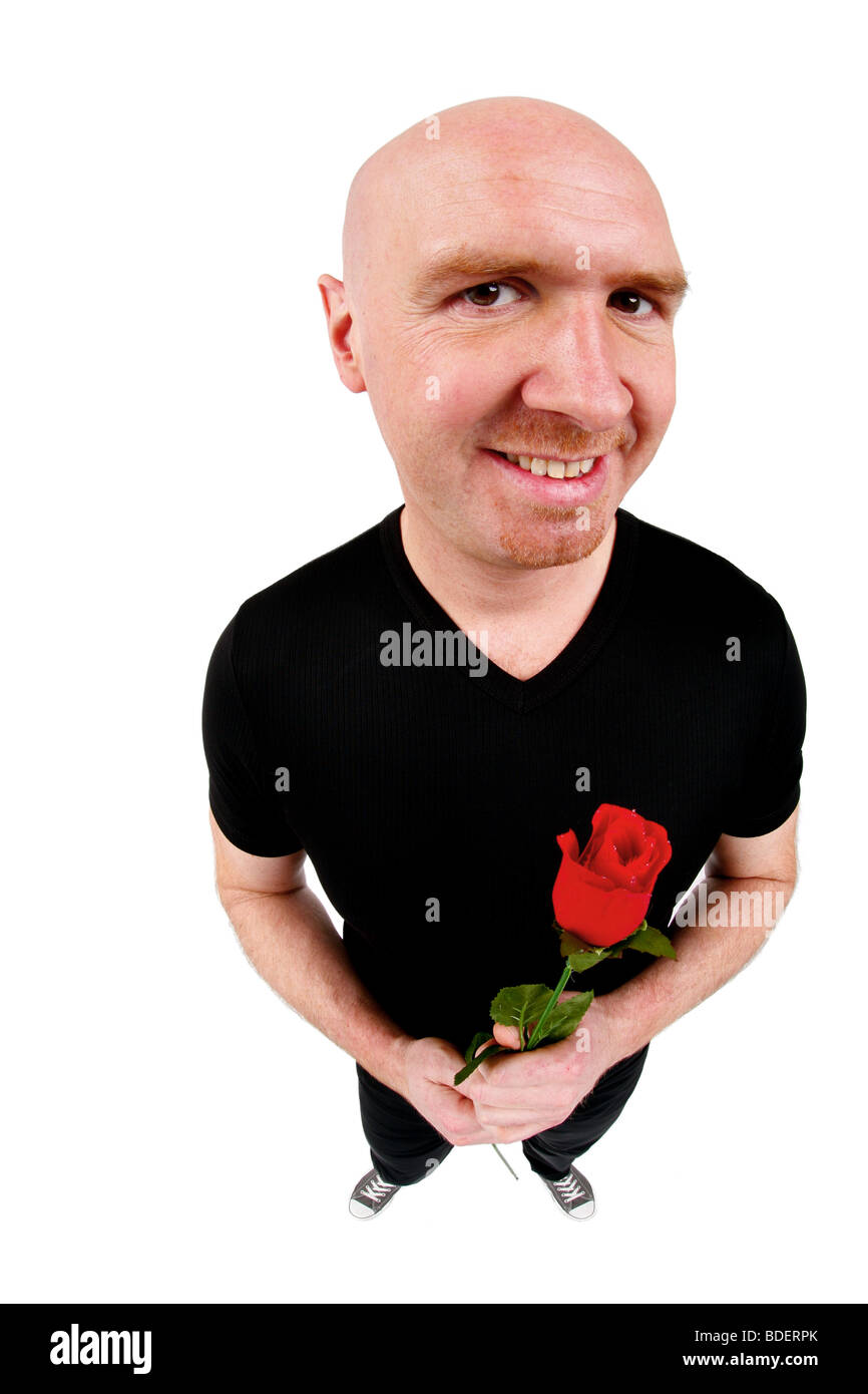 bald headed man holding a red rose in his hands Stock Photo