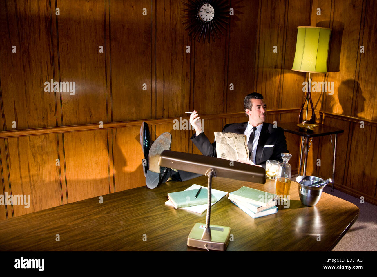 Vintage portrait of businessman relaxing with feet up smoking Stock Photo