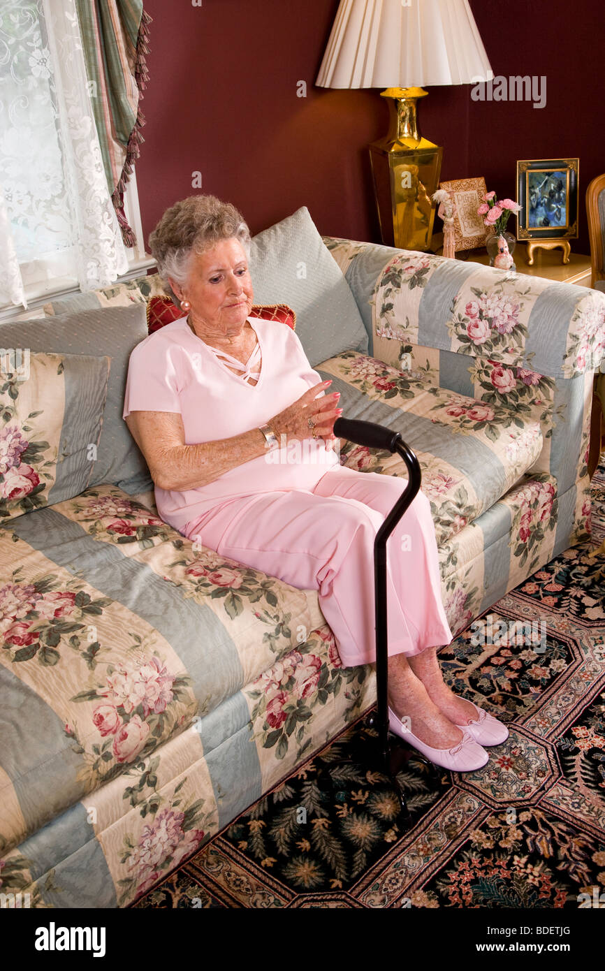 Elderly woman at home alone sitting on sofa Stock Photo - Alamy