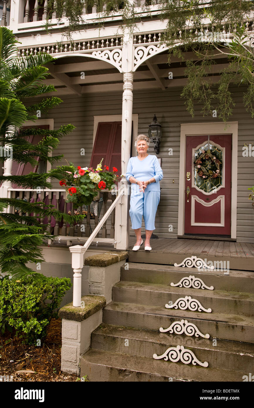 Senior woman standing on front porch of house Stock Photo Alamy