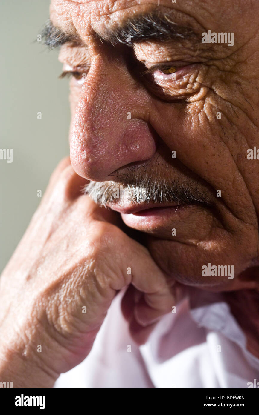Close-up of depressed senior man with hand on chin Stock Photo