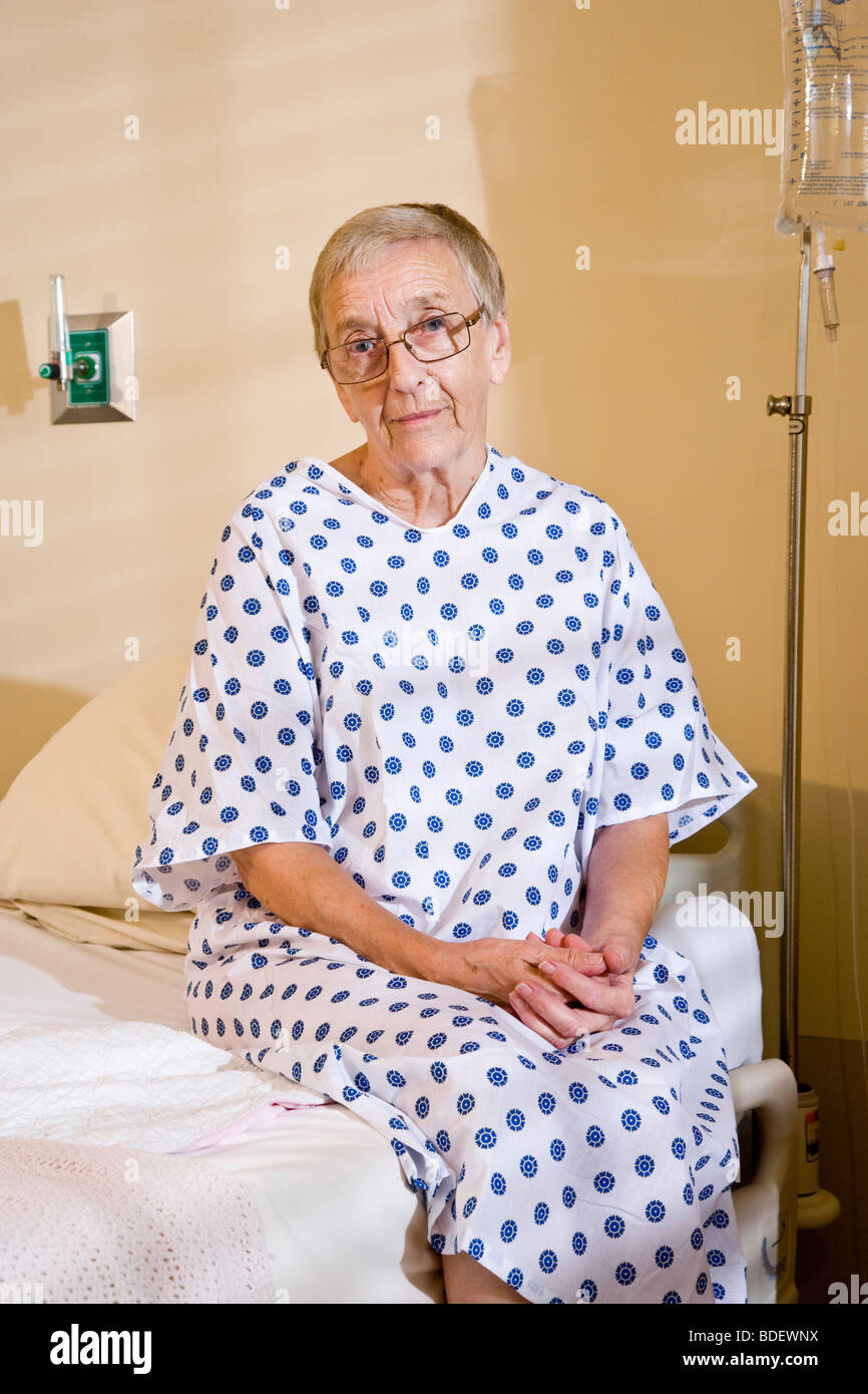 Portrait of senior woman in hospital gown sitting in hospital room