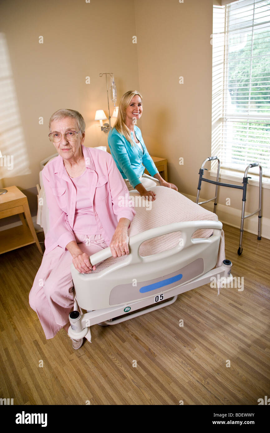 Elderly mother and daughter sitting on hospital bed in nursing home