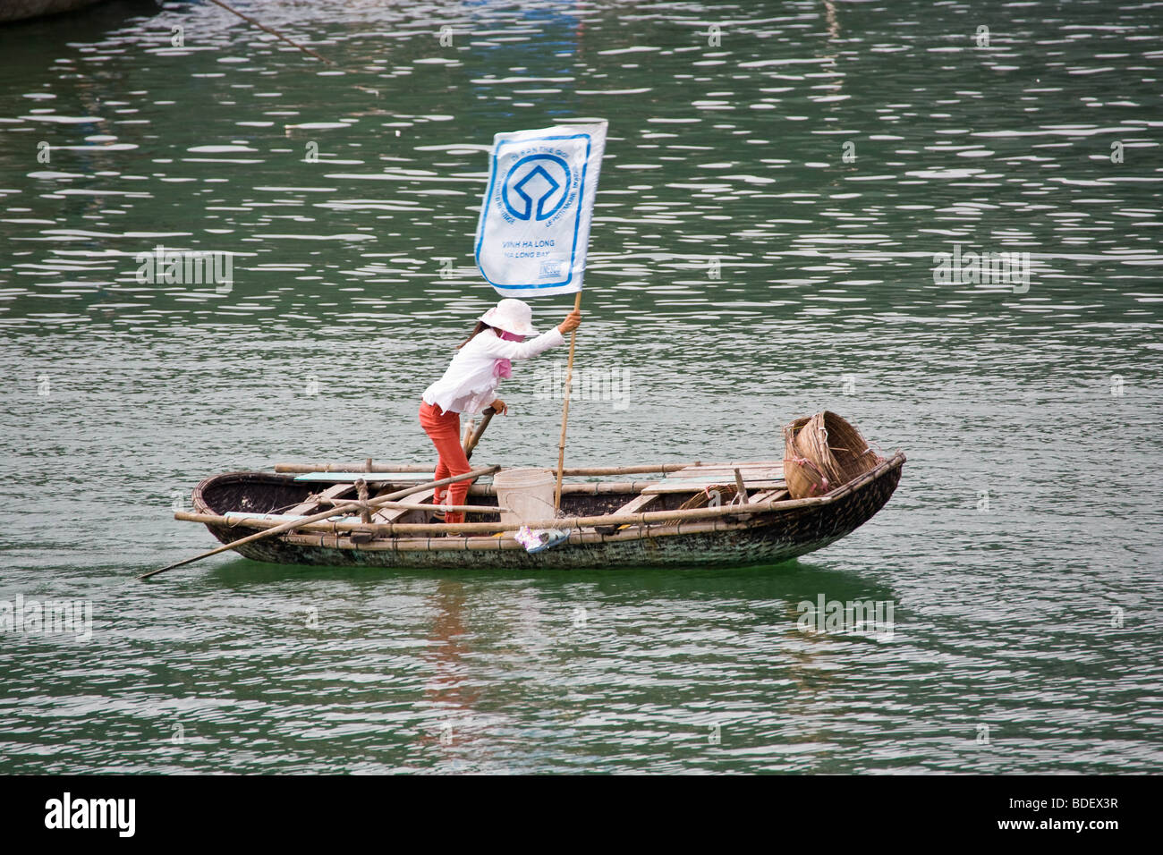 Local woman using a rice sack as a sail for a small boat in Ha Long Bay, Vietnam Stock Photo