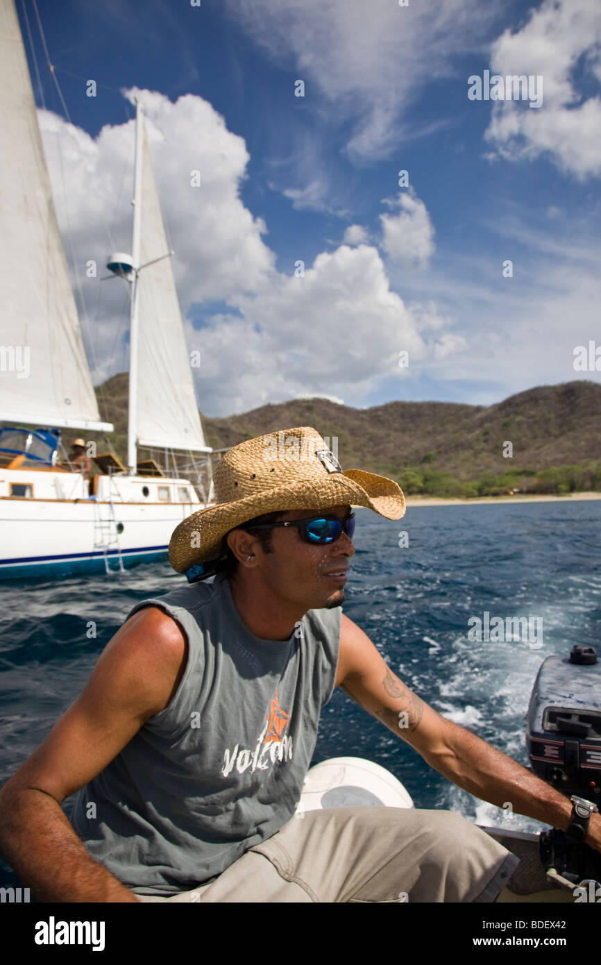 Man leading excursion from sailboat, driving skiff to shore in the Golfo de Papagayo, Guanacaste, Costa Rica. Stock Photo