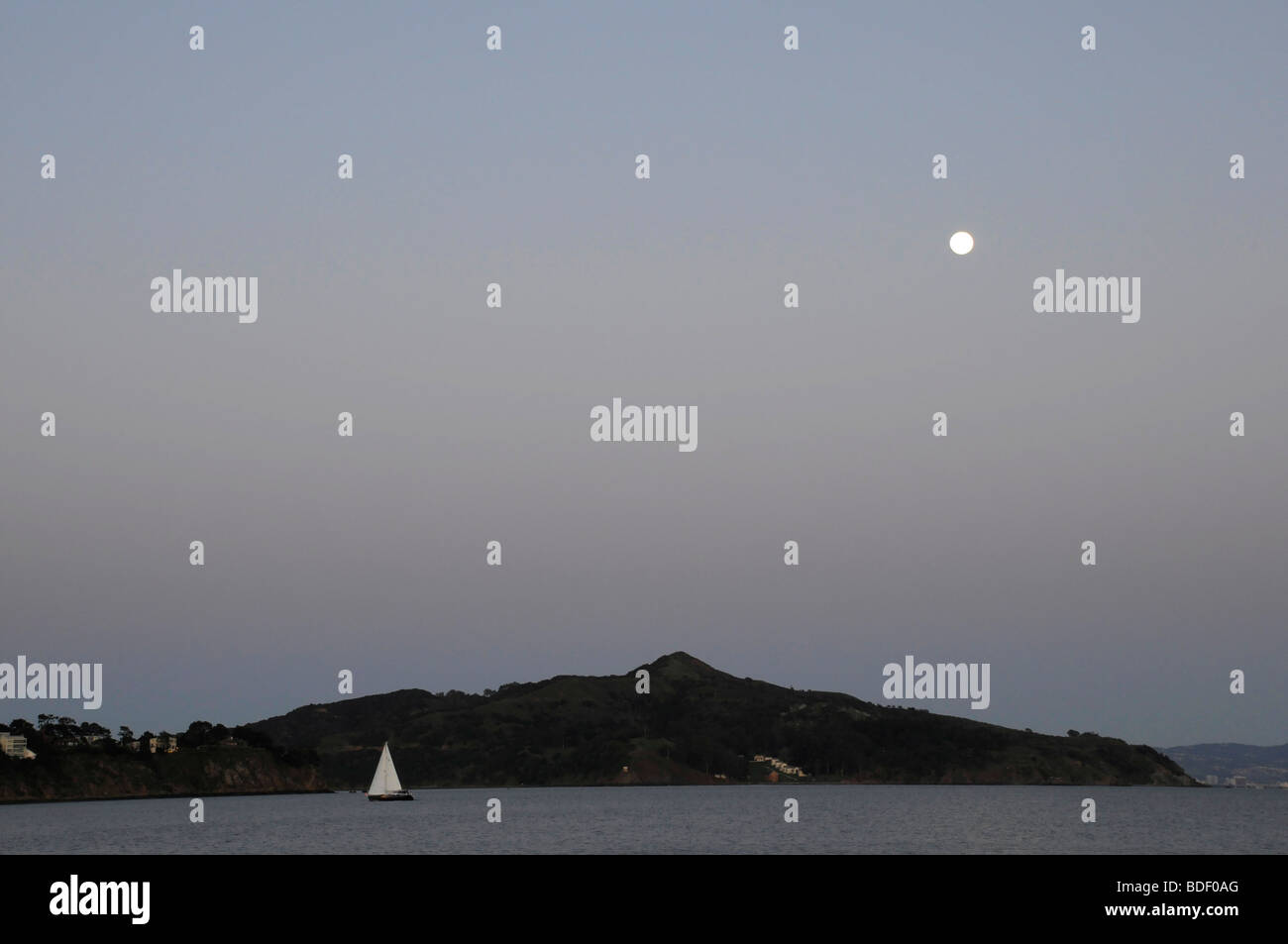 A yacht at full mast sails under a full moon on Richardson Bay ...