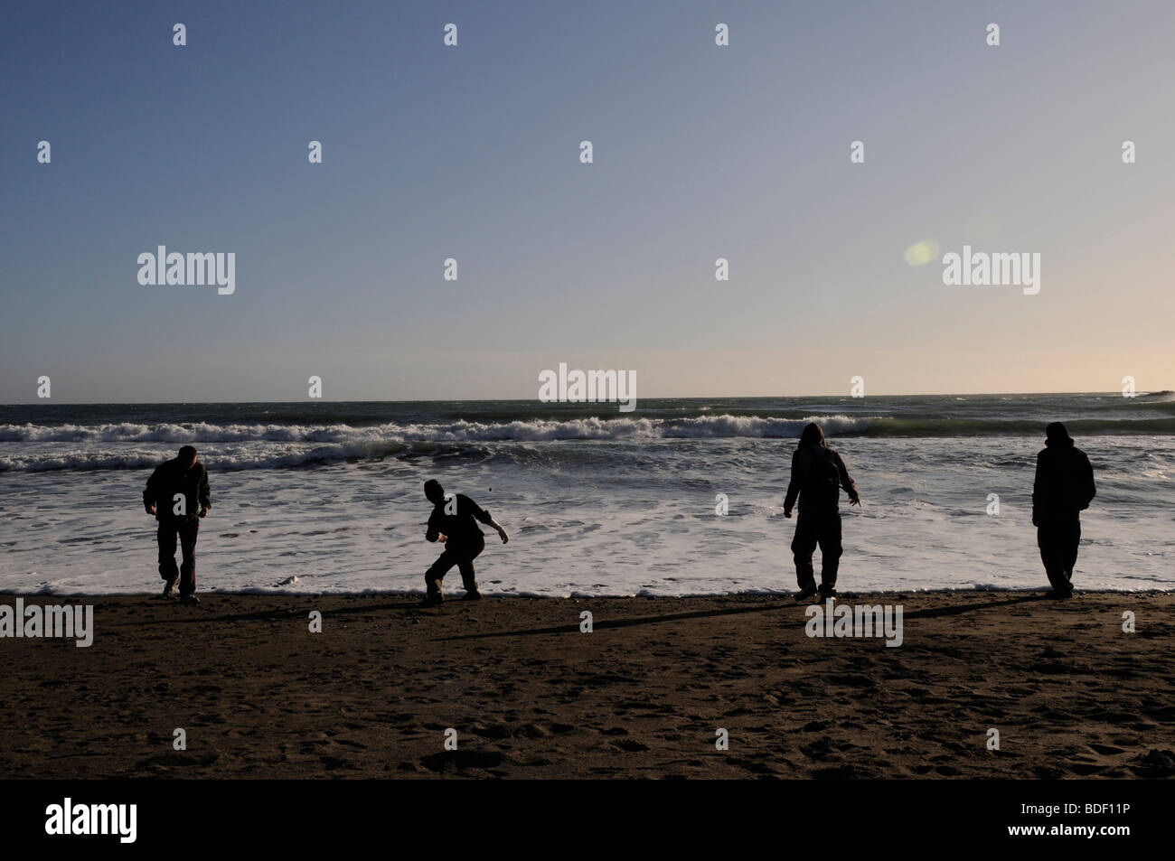 Boys skip stones into the sea and play on Muir Beach in the Golden Gate National Park, California, USA. Stock Photo