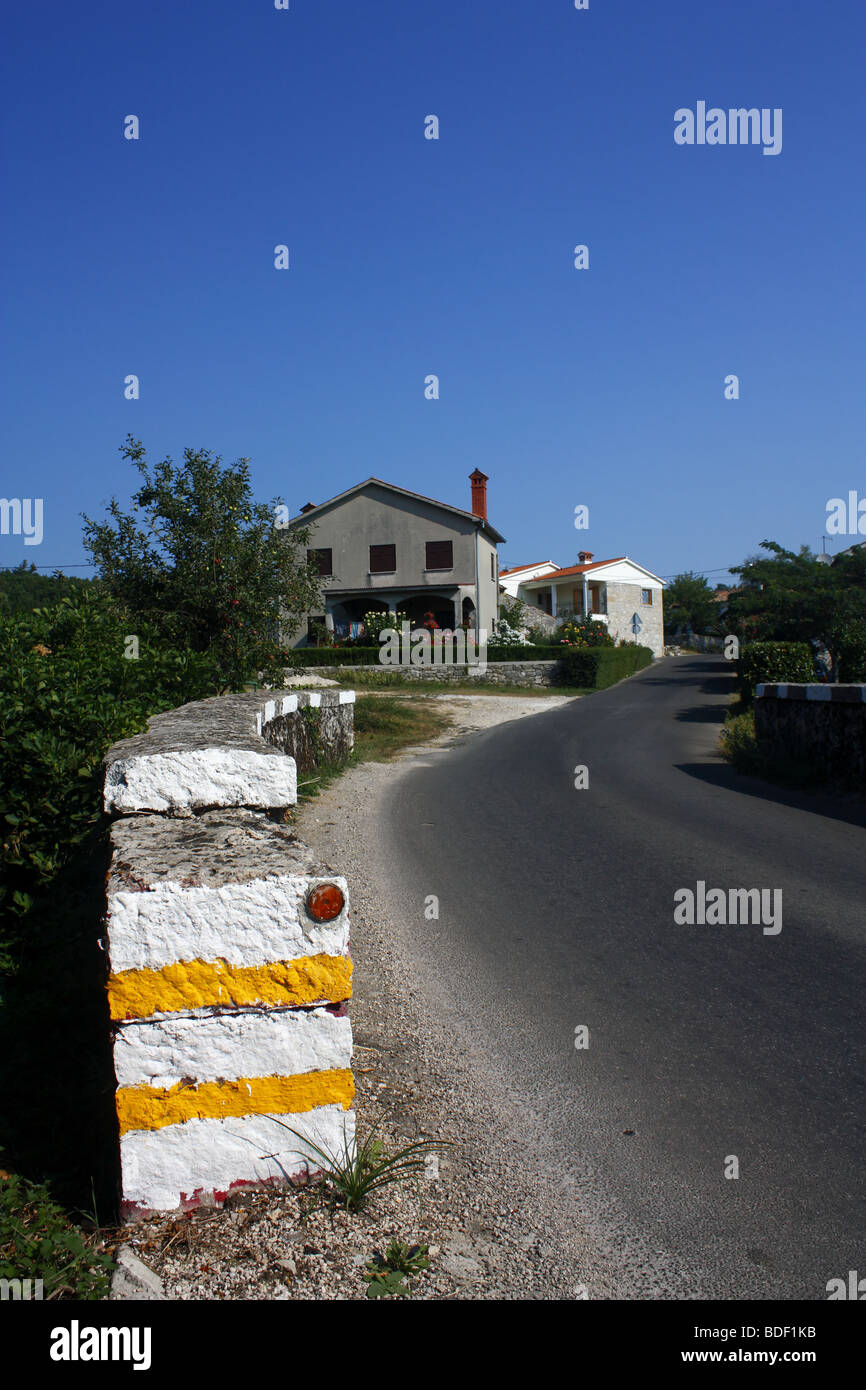 Road stone wall and houses. Stock Photo