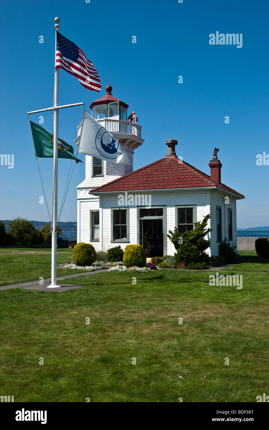 listed on the National Register of Historic Places the wooden Victorian style Mukilteo Lighthouse with flags flying Stock Photo
