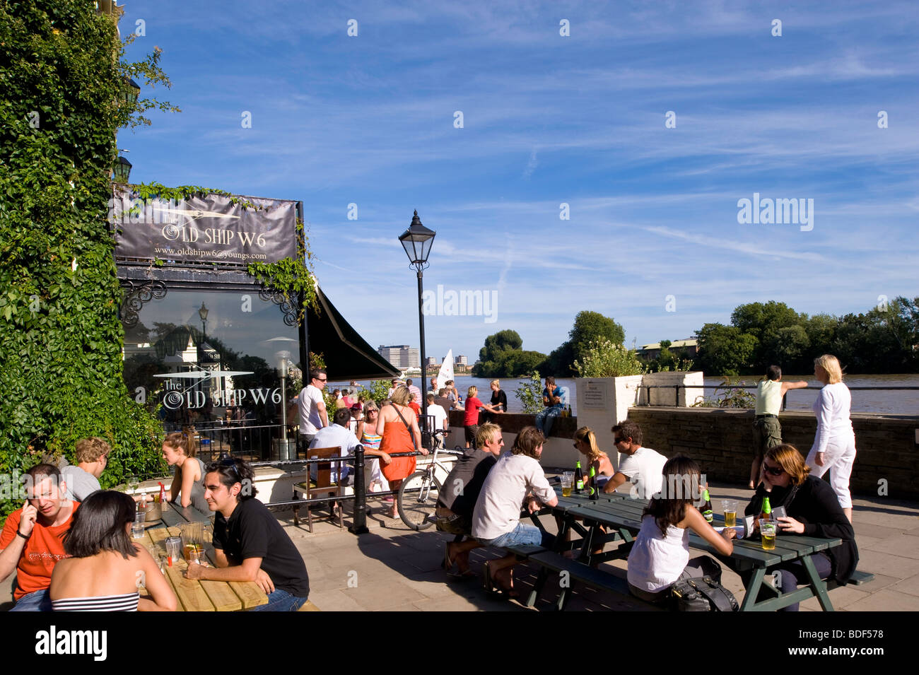 People relax in pub The Old Ship overlooking Thames river, Hammersmith, W6, London, United Kingdom Stock Photo