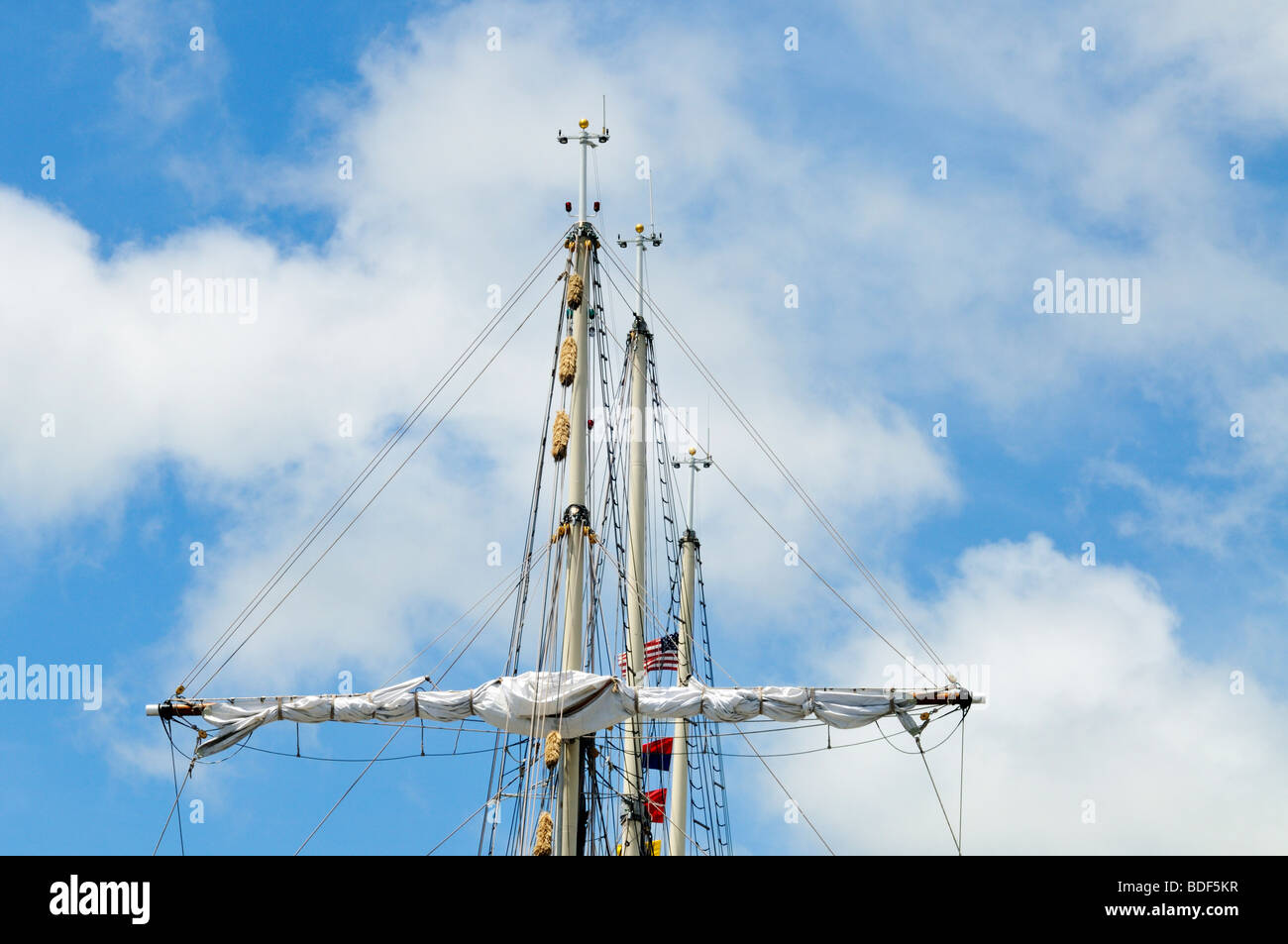 3 upper masts of tallship Peacemaker with sail furled on yardarm Stock Photo