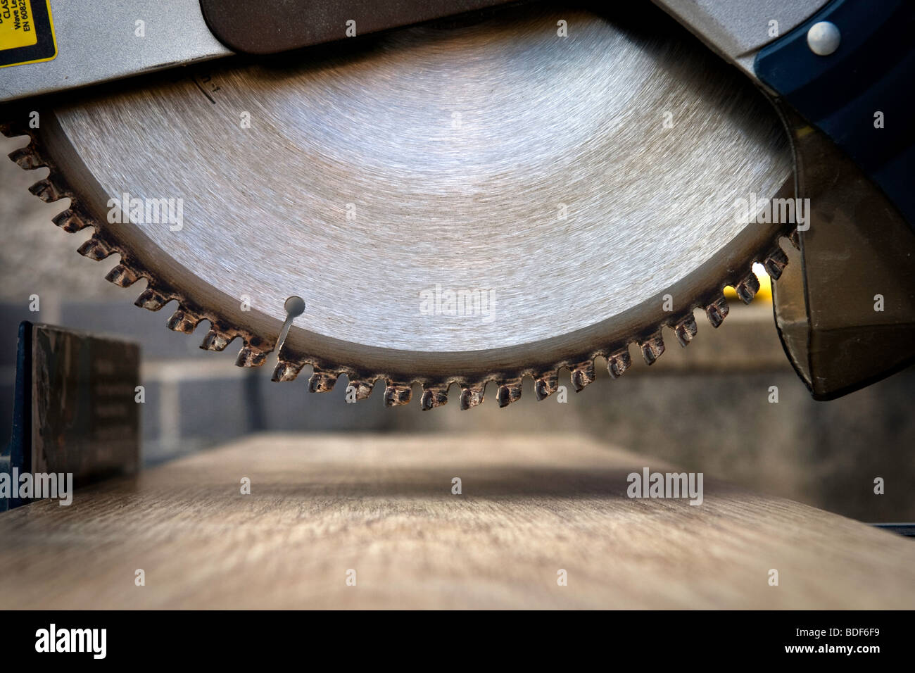 A view of a circular saw blade about to cut a piece of wood Stock Photo