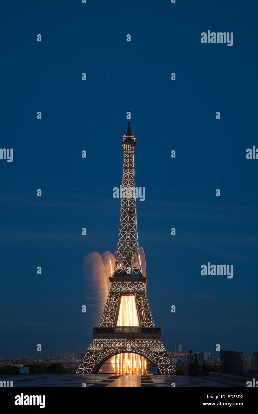 Eiffel tower, Paris, France, glowing white lights blue background  illuminated monument night fireworks in background July 14 2009 Editorial use Stock Photo