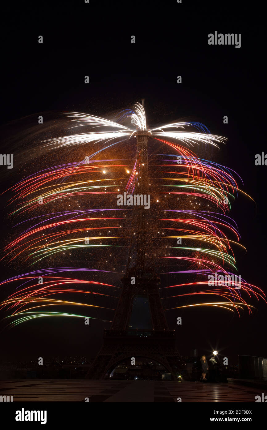 Multi-color fireworks Eiffel Tower Paris France Bastille Day independence celebration small news crew at tower base adds perspective, time lapse Stock Photo