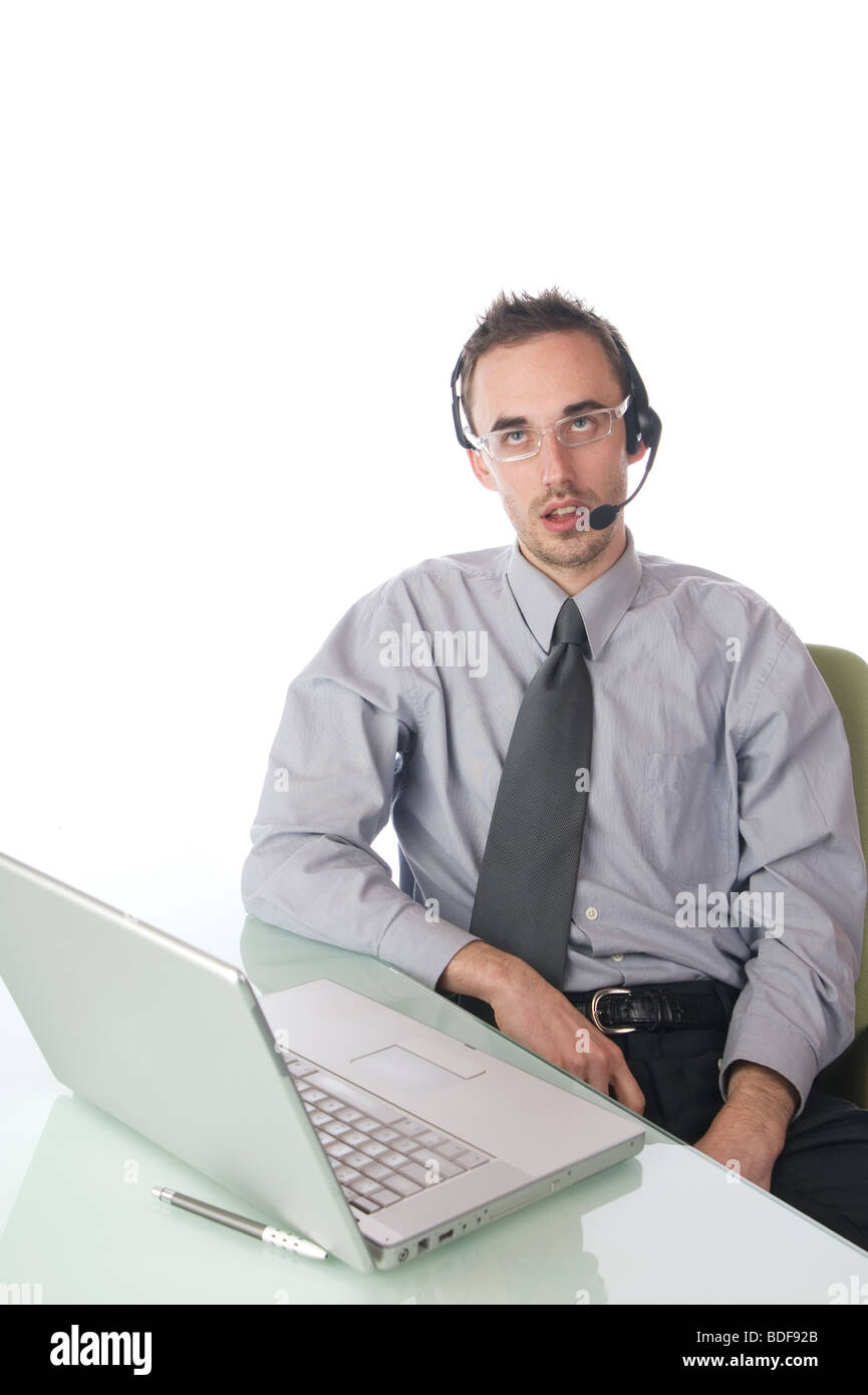 A man with headset on sitting at computer and rolling his eyes Stock Photo